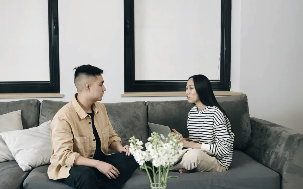 Two adults in a calm conversation on a sofa